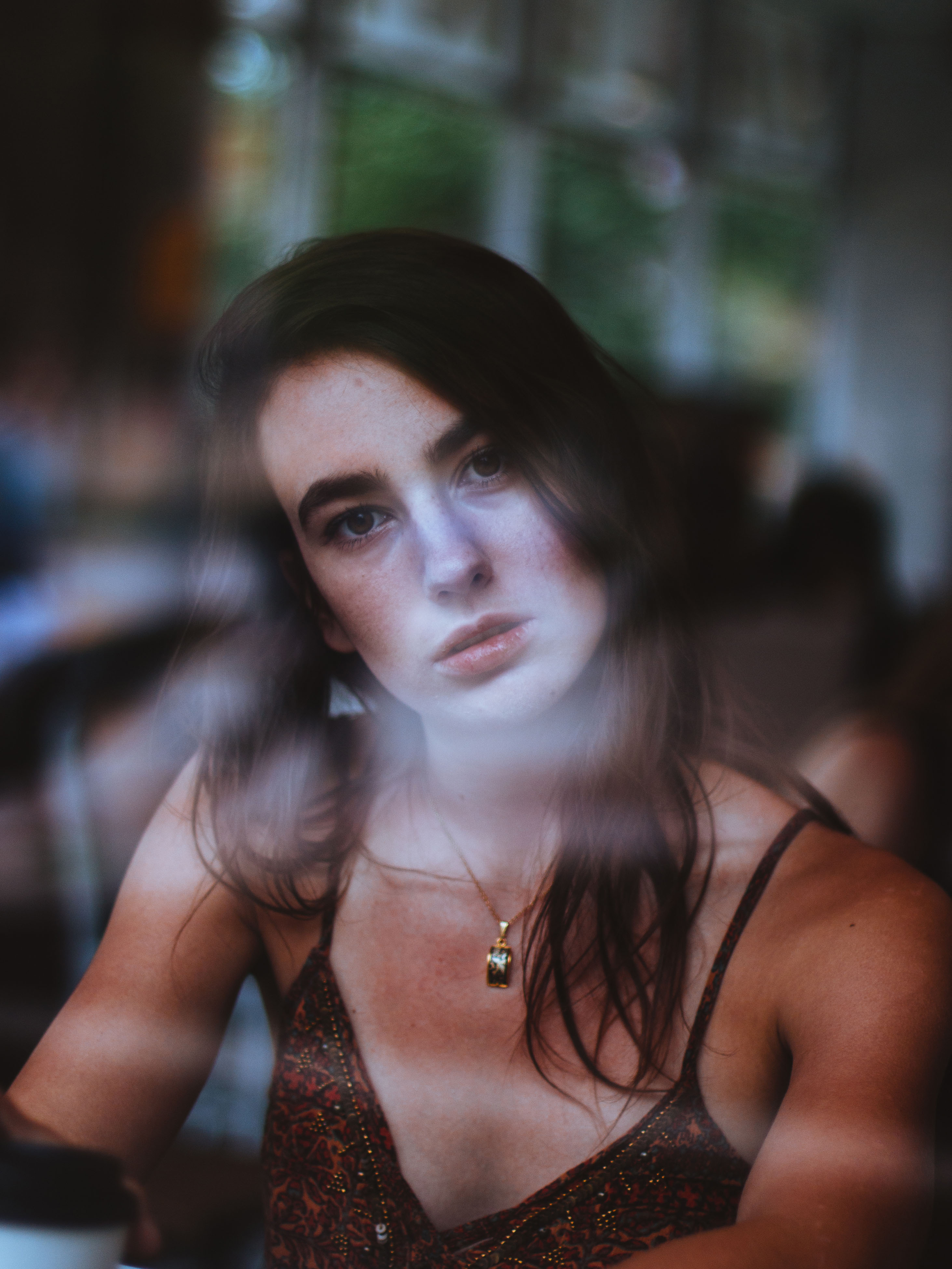 Julia Schiller through coffee window, slight head tilt, gaze on photographer